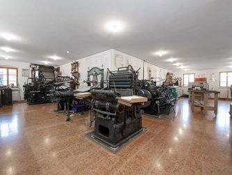 In der Druckwerkstatt sind historische Druckpressen und Druckmaschinen zu sehen.